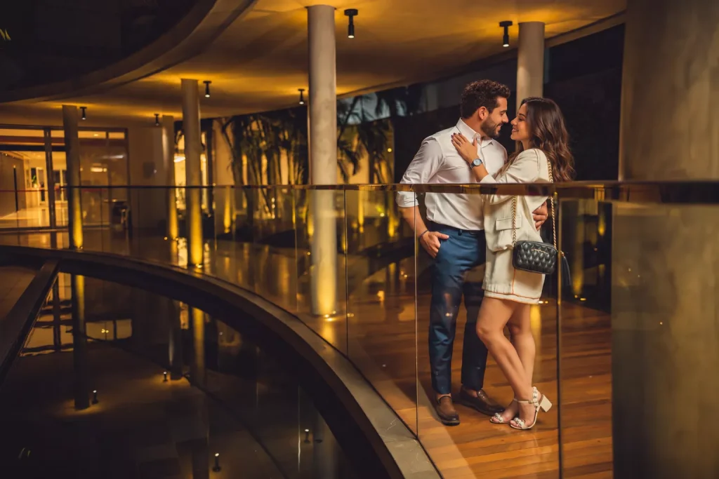 Casal no corredor iluminado do hotel